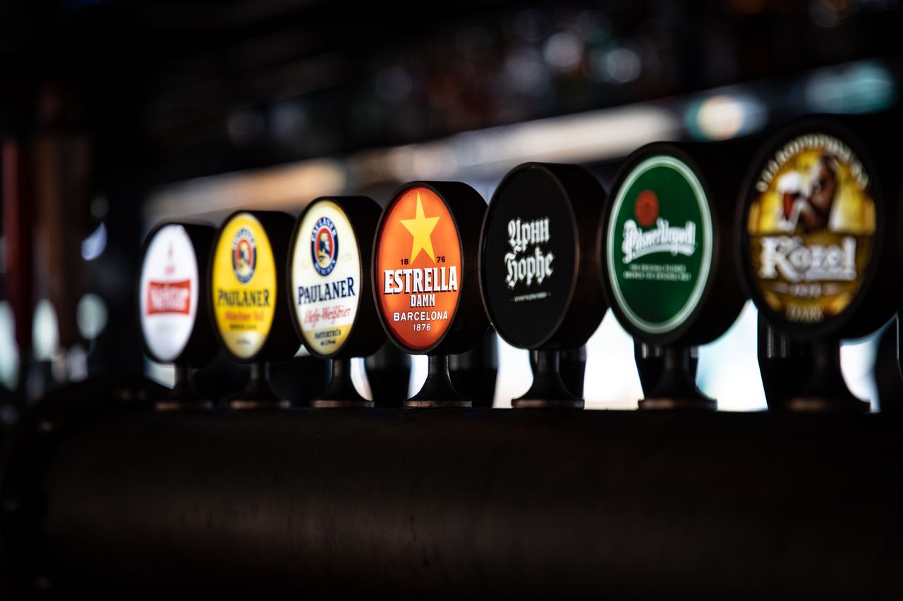 Crafting Captivating Headlines: Your awesome post title goes here A variety of beer taps featuring distinct brand labels in a row at a bar setting.